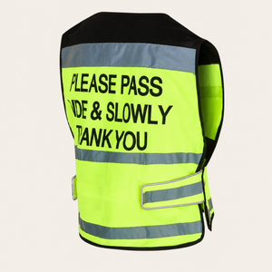 A high-visibility safety vest shown from the back, featuring a bright neon yellow-green body with reflective silver stripes and bold black text that reads 'PLEASE PASS SIDE & SLOWLY THANK YOU'.
